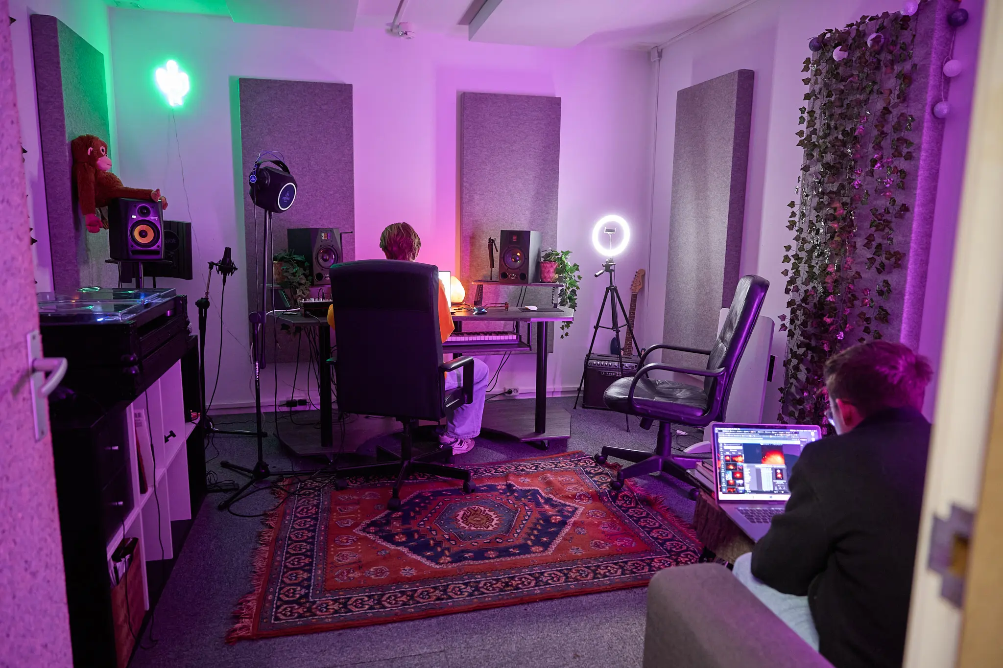 donkere muziekstudio waar twee mensen aan het werk zijn