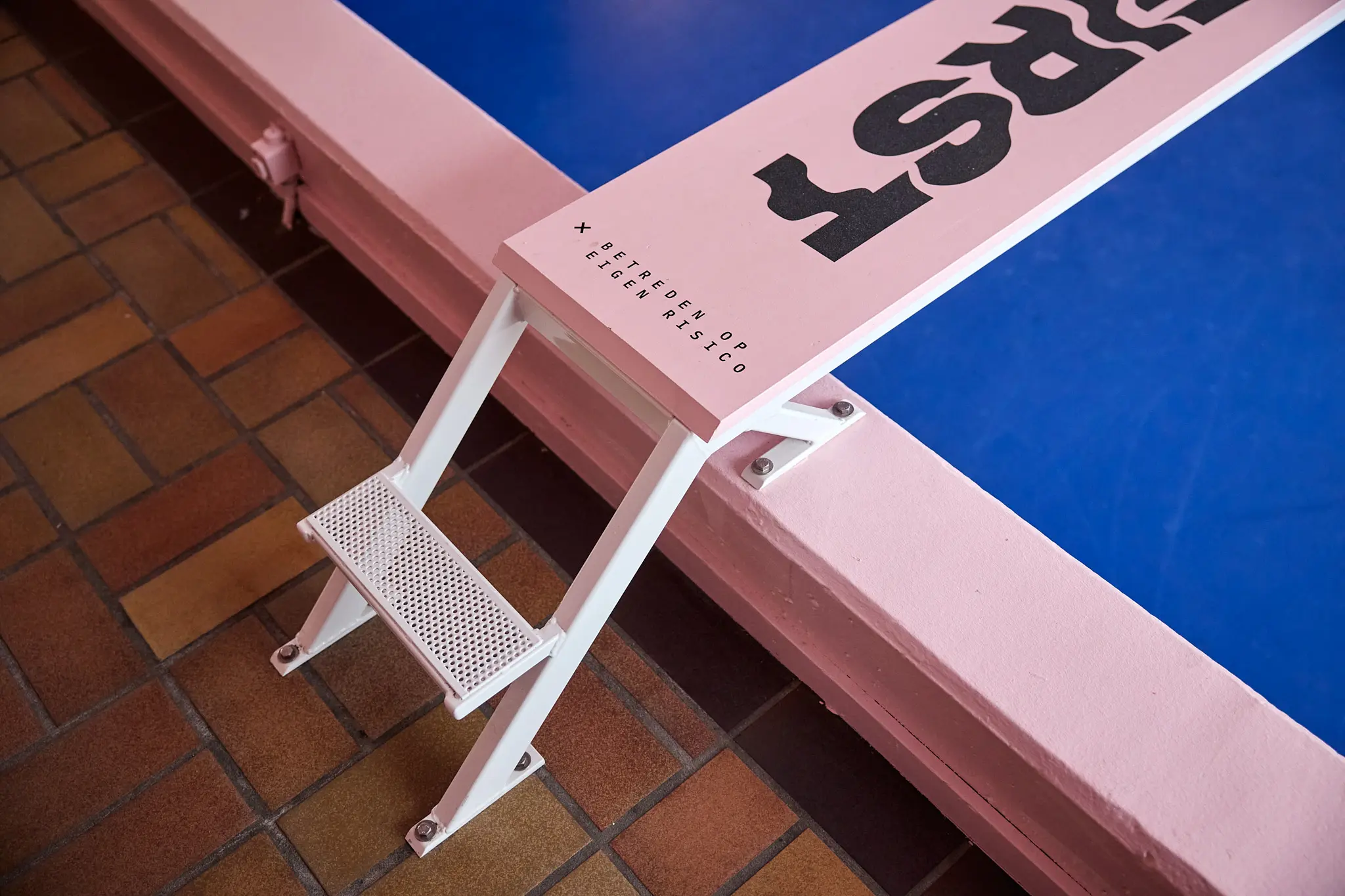 close up van een duikplank met daarop de tekst betreden op eigen risico